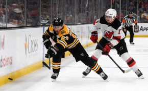 Boston Bruins left wing Brad Marchand and New Jersey Devils center Yegor Sharangovich battle for puck