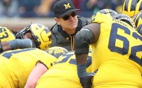 Jim Harbaugh huddles with his players