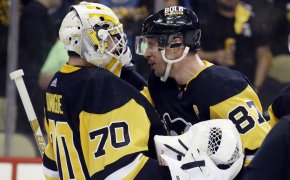 Pittsburgh Penguins goaltender Louis Domingue celebrates with center Sidney Crosby