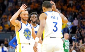 Warriors teammates Stephen Curry and Jordan Poole high five.