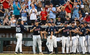 Ole Miss pitcher greets teammates during College World Series.