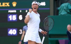Ons Jabeur celebrating with a fist pump during a match at Wimbledon.