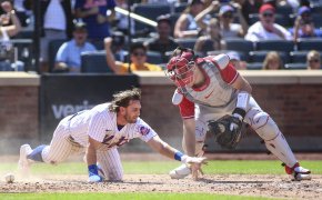 Mets second baseman Jeff McNeil scores before Phillies catcher J.T. Realmuto is able to apply the tag