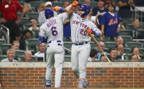 Mets players celebrating after scoring a run.