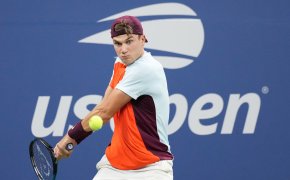 Jack Draper hitting a backhanded shot during a tennis match at the US Open.
