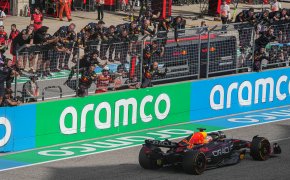 Team Oracle Red Bull Racing hangs off the pit wall as Max Verstappen wins a race