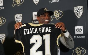Deion Sanders holds up a Coach Prime jersey