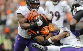 Joe Mixon is wrapped up by multiple Ravens defenders.