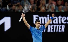 Novak Djokovic with his hands in the air after winning a match at the Australian Open.
