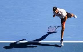 Ben Shelton hitting a serve during a tennis match at the Australian Open.