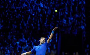 Novak Djokovic serving a ball during a tennis match.