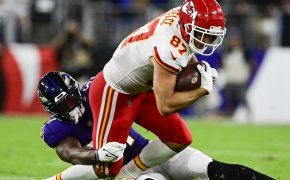 Kansas City Chiefs tight end Travis Kelce being tackled a Baltimore Ravens player.