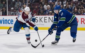 Nathan MacKinnon and Tyler Myers battle for the puck