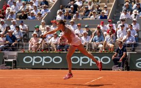 Aryna Sabalenka following through on a serve during a tennis match at the French Open.