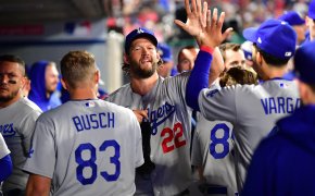 Clayton Kershaw high-fives teammates in the dugout