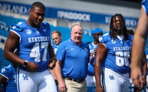 Kentucky Wildcats football coach Mark Stoops with players blue uniforms