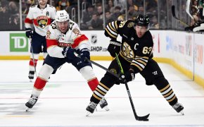 Boston Bruins left winger Brad Marchand skates with the puck while Florida Panthers center Carter Verhaeghe tries to stick-check him