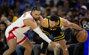 Golden State Warriors guard Stephen Curry holds off Houston Rockets guard Dillon Brooks