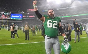 Philadelphia Eagles player Jason Kelce walking hand raised green jersey