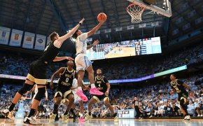 University of North Carolina Tar Heels guard Elliot Cadeau attempts a layup at the basket defended by the Wake Forest Demon Deacons.