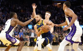 Golden State Warriors guard Stephen Curry drives against three Sacramento Kings defenders