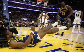 Golden State Warriors forward Jonathan Kuminga laying on the court after making a basket