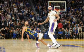 Golden State Warriors guard Stephen Curry falls after shooting over Los Angeles Lakers forward Anthony Davis