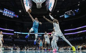 Charlotte Hornets guard Vasilije Micic attempts a layup on a hoop guarded by Memphis Grizzlies forward Brandon Clarke.