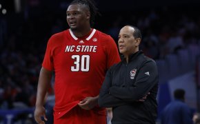 NC State basketball player and coach standing beside each other