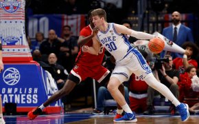 Duke Blue Devils basketball player Kyle Filipowski dribbles a basketball while being defended by NC State Wolfpack player Mohammed Diarra.
