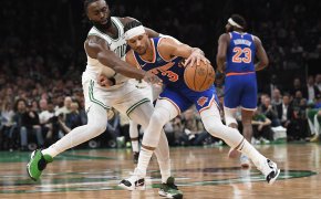 New York Knicks guard Josh Hart defends a basketball from Boston Celtics guard Jaylen Brown.