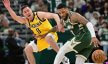Milwaukee Bucks guard Damian Lillard dribbles around Indiana Pacers guard TJ McConnell