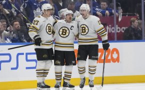 Boston Bruins defenseman Hampus Lindholm and forward Charlie Coyle congratulate forward Brad Marchand