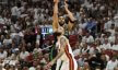 Boston Celtics forward Jayson Tatum shoots a three over Miami Heat forward Caleb Martin