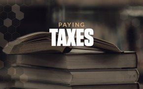 Paying taxes text overlay on stack of books