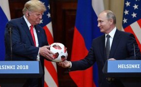 Vladimir Putin gives Donald Trump a soccer ball.